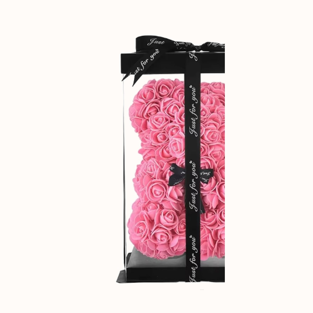 The rose bear inside its clear gift box, tied with ribbon